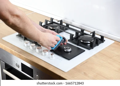 Person cleaning gas burner parts